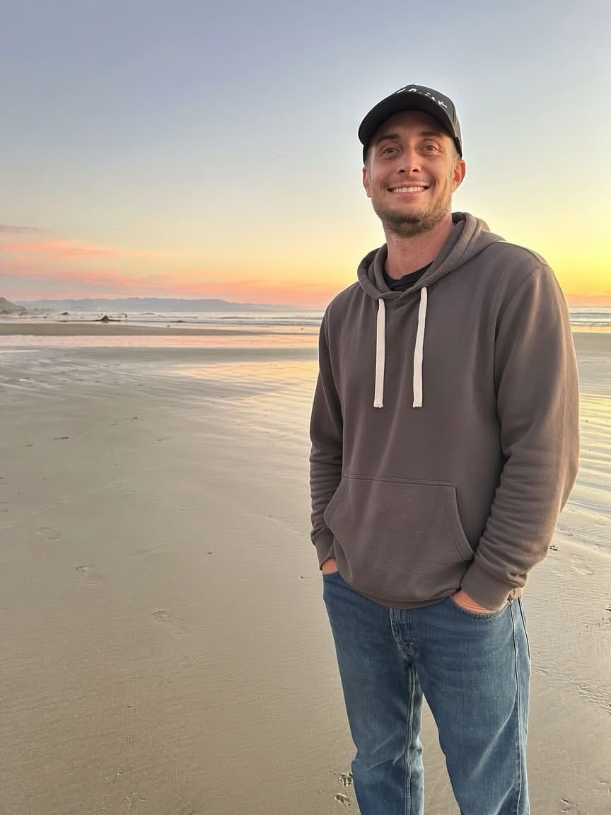 Garrett Doss (GRT) on the beach at sunset Garrett Doss (GRT) smiling on a beach at sunset in a hoodie and cap